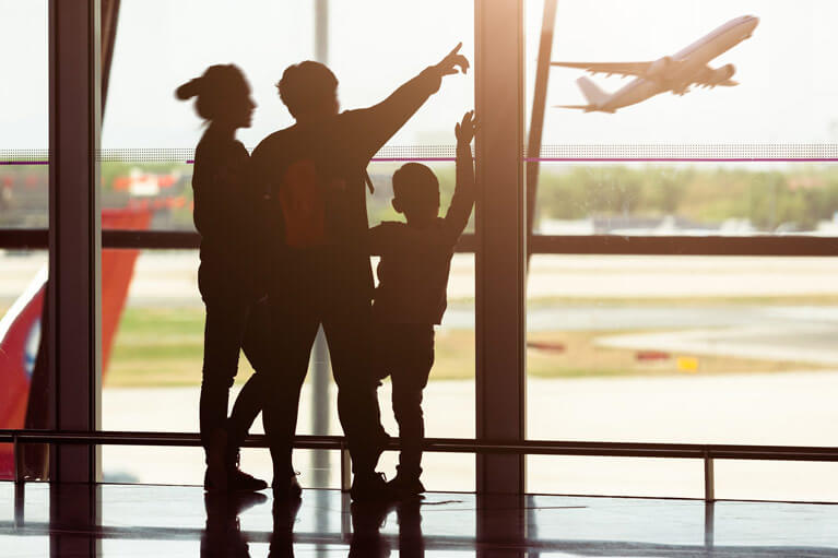 Młoda rodzina obserwująca startujący samolot na lotnisku - delayfix.com